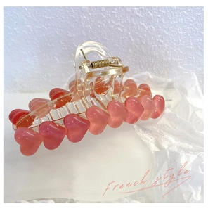 Dettaglio molletta per capelli stile francese con cuori rosa e molla dorata