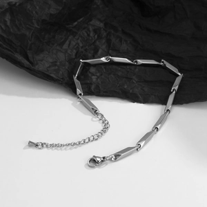 Détail macro du bracelet à maillons losanges argentés avec finition polie et fermoir mousqueton