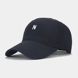 Detailed close-up of white embroidered letter N on a black cotton baseball cap