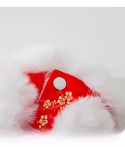 Close-up of red festive pet vest with golden plum blossom embroidery and white faux fur trim