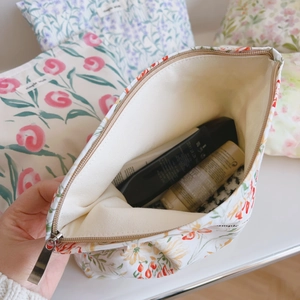 Détail de l'ouverture large et de la doublure florale de la trousse de toilette en coton