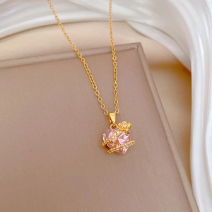 Macro detail of gold necklace with pink heart crystal and sparkling floral accents