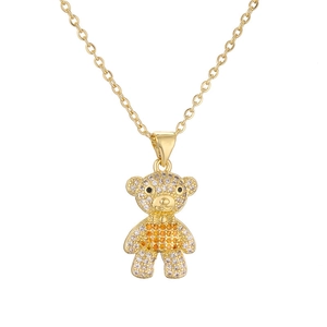 Macro detail of bear pendant with white and orange rhinestones on gold necklace