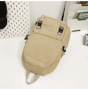 Primer plano de la mochila de nailon beige con hebillas negras y detalles de cremallera