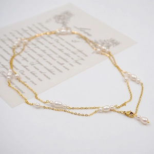 Elegant gold double-layered freshwater pearl necklace shown on a vintage card background