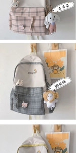 Detail of plaid canvas backpack with cute plush bunny and bear charms for students