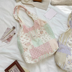 Dettaglio borsa tote patchwork con motivi floreali, quadretti e logo Sozakka