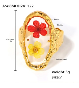Macro view of stainless steel ring featuring resin dried flowers and gold frame