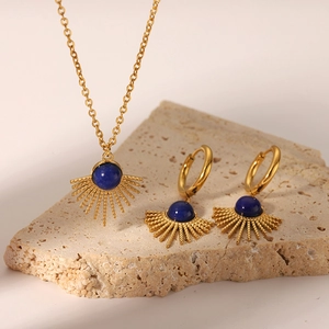 Detailed close-up of golden sunflower jewelry set with blue lapis lazuli on stone