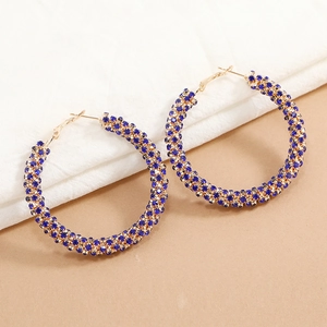 Detailed macro view of large gold hoop earrings with sparkling blue rhinestones