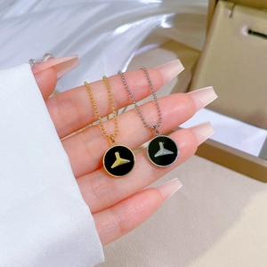 Minimalist mermaid tail necklaces in gold and silver with black enamel disc pendants
