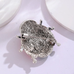 Silver ladybug brooch with textured honeycomb backing and secure safety pin fastener