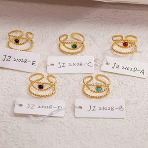 Flat lay of five 18k gold-plated stainless steel rings with colorful natural stone inlays