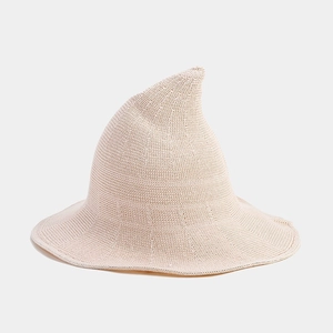 Detail of light beige knitted fabric texture on pointed brimmed Halloween witch hat