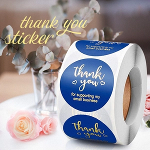 Macro shot of navy blue thank you stickers with gold foil hearts on a roll