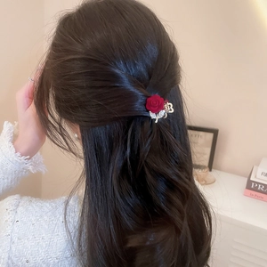 Detail of red flocked rose hair claw with gold leaves and rhinestones on half-up hair
