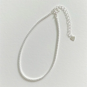 Macro detail of S925 sterling silver tennis anklet with zircon and heart charm
