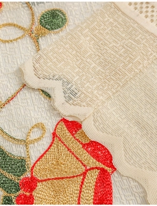 Macro detail of Christmas bell embroidery on white lace curtain with golden threads