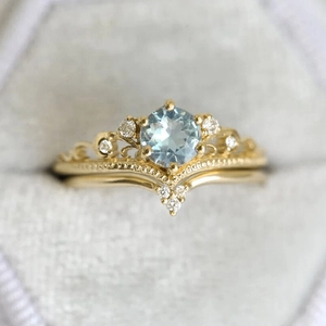 Macro detail of crown design vintage gold rings with blue zircon in a velvet box