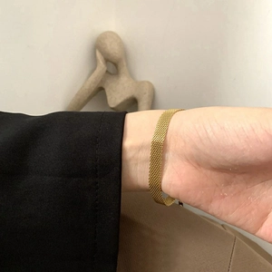 Minimalist 18K gold plated mesh chain bracelet for women on wrist over black suit