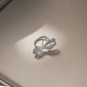 Macro shot of a silver bow ring with shimmering cubic zirconia settings and polished finish