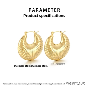 Macro detail of U-shaped gold stainless steel earrings with textured stripe finish