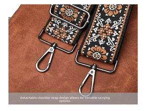 Detail of detachable wide shoulder strap with ethnic embroidery and metal hooks