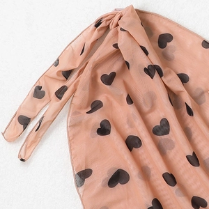 Détail de la jupe de plage en tulle pêche avec imprimé petits coeurs noirs