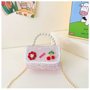 Détail du sac fille en tweed rose avec poignée en perles et bandoulière chaîne