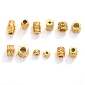 Detailed view of various golden engraved stainless steel spacer beads for jewelry making