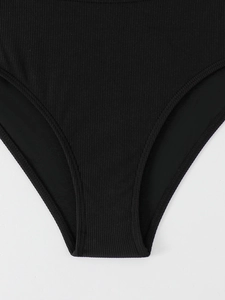 Detail of black ribbed knit swimwear fabric showing texture and stitching quality