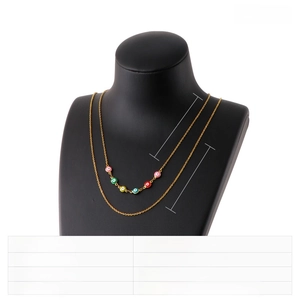 Detail of layered gold titanium necklace with multi-colored resin evil eye charms