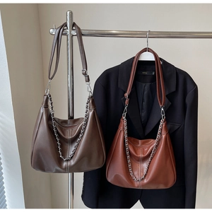 Detail of hobo shoulder bags in dark coffee and reddish brown with metallic chain straps