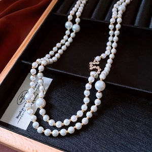Detail view of double-layer pearl necklace with zircon accents in a black jewelry box