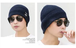 Detail of navy knit beanie with AMBITIONS patch and stylish aviator sunglasses