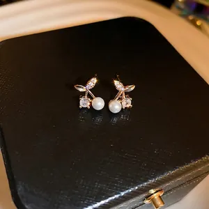 Elegant cherry pearl earrings with sparkling cubic zirconia on a black jewelry box