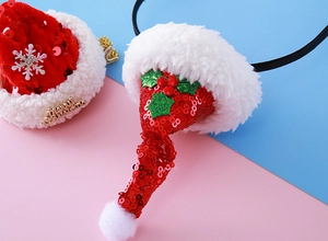 Détail d'un serre-tête de Noël rouge avec paillettes brillantes et bordure en peluche