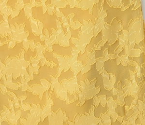 Makroaufnahme von gelbem Jacquard-Stoff mit feiner Blumenwebung und Texturdetails