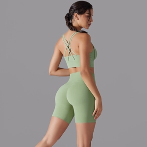 Dettaglio dei pantaloncini yoga a vita alta e reggiseno sportivo verde salvia