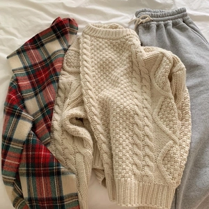 Christmas red plaid fringe scarf paired with cream knit sweater and grey joggers flat lay