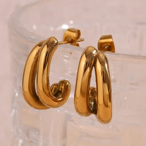 Detail shot of 18K gold-plated double-row U-shaped earrings on a textured glass rim