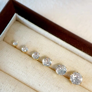 Close-up of 18k gold-plated stud earrings in six sizes with cubic zirconia stones