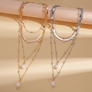 Multi-layer necklace featuring a pearl drop pendant in gold and silver finish options