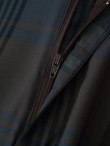 Gros plan détaillé sur la fermeture éclair et le tissu à carreaux de ce pantalon décontracté