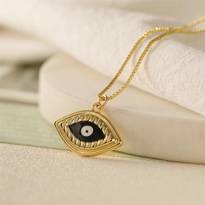 Vue macro du collier pendentif œil maléfique doré avec détails en émail noir et blanc