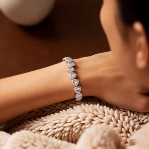 Close-up of heart-shaped zircon bracelet on wrist with elegant silver-tone finish