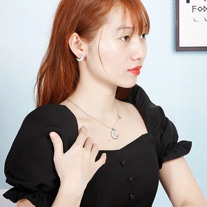 Close-up of elegant star and moon jewelry set with white mother of pearl on a model