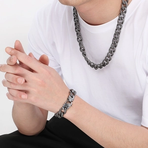 Close-up of vintage stainless steel Cuban chain necklace and dragon clasp bracelet