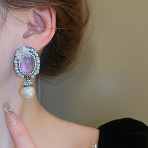 Detailed view of vintage French style earring with pink stone, butterfly and pearl drop