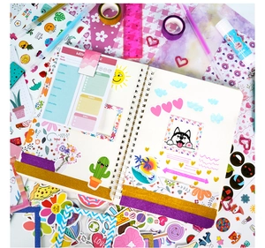 Macro shot of DIY journal kit featuring a weekly planner, colorful stickers, and glitter tapes